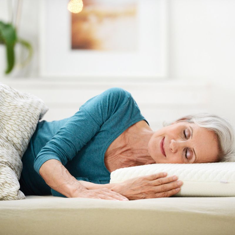 Femme âgée allongée sur le SISSEL® DREAM COMFORT Oreiller à mémoire de forme