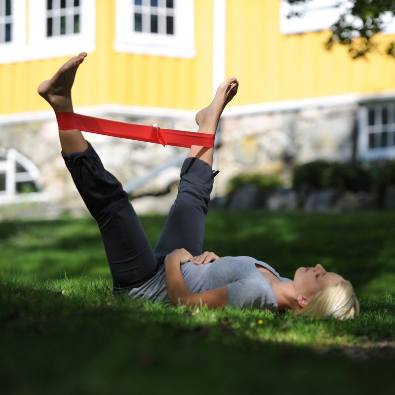 Femme allongée dans l'herbe avec la FITBAND Rouge 25m