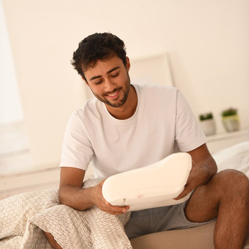 Homme heureux et souriant avec un SISSEL® Oreiller Compact Homme heureux et souriant avec un SISSEL® Oreiller Compact