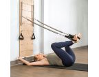 Femme utilisant un Pilates Springboard™ pour une posture de Pilates avec jambes écartées